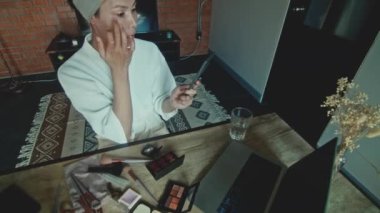 Young Asian transgender queer man learns how to do makeup online on laptop