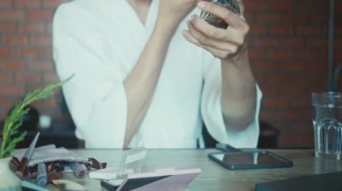 Young asian transgender queer man does his makeup in his room while getting ready for a date