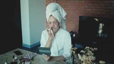 Young asian transgender queer man does his makeup in his room while getting ready for a date