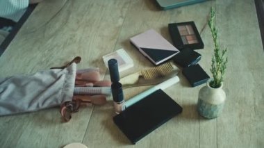 Top view of womans dresser desk, hands uses cosmetics