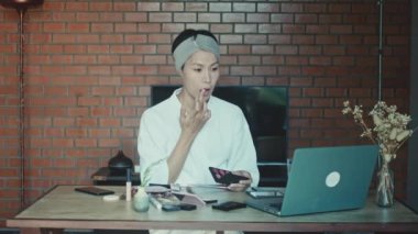 Young Asian transgender man learns online how to do makeup 