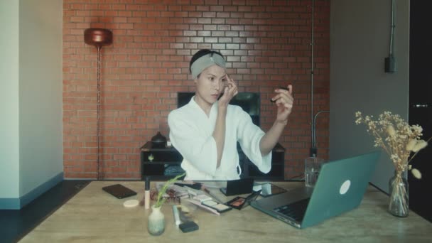 若いアジアのトランスジェンダーの男は化粧をする方法をオンラインで学ぶ — ストック動画