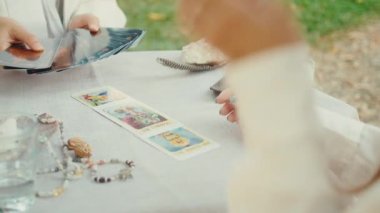 Kel falcı tarot kartları okuyor, bir müşteri için okuma yapıyor. Yavaş çekim