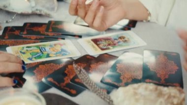 Falcı tarot kartları okuyor, bir müşteri için okuma yapıyor. Yakın çekim yavaş çekim.