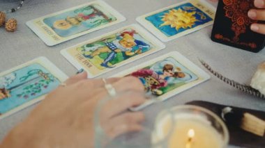 Falcı tarot kartları okuyor, bir müşteri için okuma yapıyor. Yakın çekim yavaş çekim.