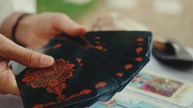 Falcı tarot kartları okuyor, bir müşteri için okuma yapıyor. Yakın çekim yavaş çekim.