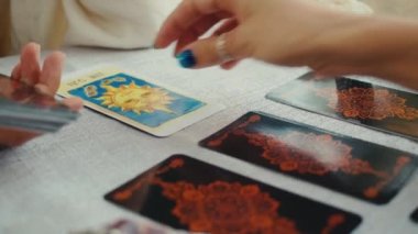 Falcı tarot kartları okuyor, bir müşteri için okuma yapıyor. Yakın çekim yavaş çekim.