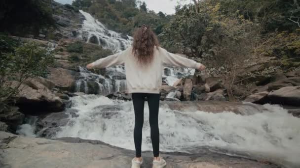 Молодая Женщина Поднимает Руки Воздухе Величественного Водопада Севере Таиланда Замедленное — стоковое видео