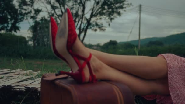 复古手提箱上穿着红鞋子的女脚特写 高质量的4K慢镜头 — 图库视频影像