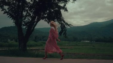 Klasik elbiseli ve kırmızı ayakkabılı bir kadın yolda yürüyor. Yüksek kalite ağır çekim 4k görüntü