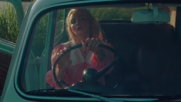 Girl Pink Vintage Dress Sits Turquoise Colored Retro Car Backdrop — Vídeos de Stock