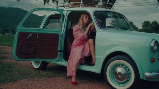 Girl Pink Vintage Dress Sits Turquoise Colored Retro Car Backdrop — Video Stock