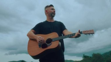 Gitarist duygusal olarak çalıyor ve şarkı söylüyor. Yüksek kaliteli el kamerası görüntüsü 4K