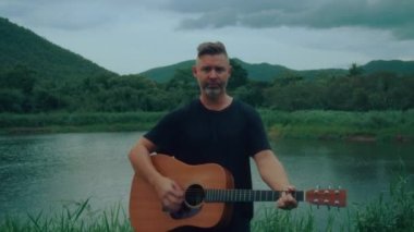 Gitarist duygusal olarak çalıyor ve şarkı söylüyor. Yüksek kaliteli el kamerası görüntüsü 4K