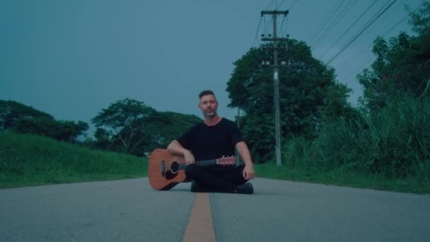 吉他手坐在路上 高品质手持镜头4K镜头 — 图库视频影像