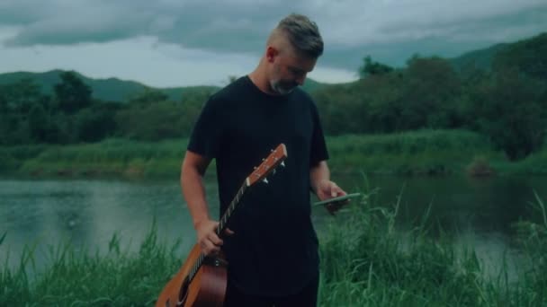 Kytarista Používá Svůj Smartphone Venku Kvalitní Ruční Záběr Záběry — Stock video