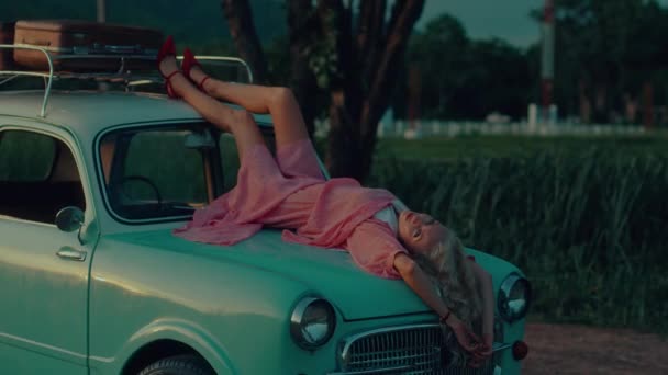 Een Blondine Een Roze Vintage Jurk Ligt Motorkap Van Een — Stockvideo