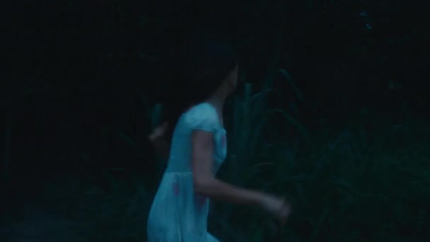 血まみれの服を着た恐ろしい少女が森の中を追い払って逃げ出した ブラックマジック6K映像 — ストック動画