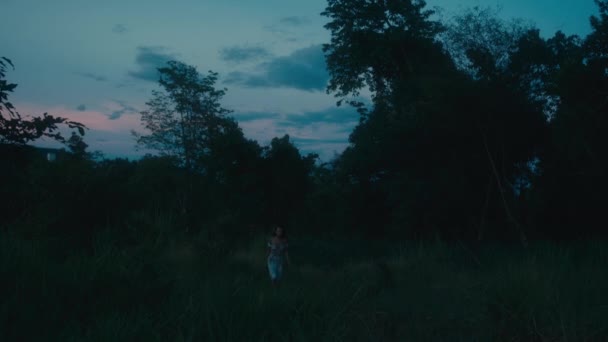 血まみれの服を着た恐ろしい少女が森の追跡者から逃げ出した ブラックマジック6K映像 — ストック動画