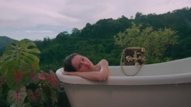 一个女人带着美丽的景色在山上的一个华丽的地方洗了个热水澡 黑魔法6K镜头 — 图库视频影像