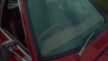 Vahşi bir kız klasik kırmızı bir arabada oturmuş yola çıkmaya hazırlanıyor. Yüksek kalite 4k görüntü