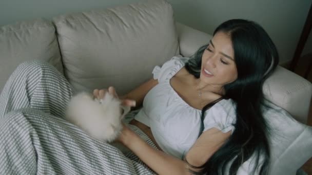 Young Thai Woman Petting Cute White Spitz Dog Lying Her — Stock Video