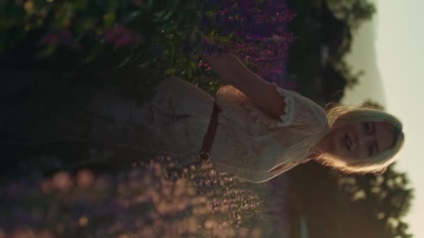 一个穿着白色花边裙的金发年轻女子在金色的时辰漫步在美丽多彩的紫罗兰花田 夏天的概念 大自然 野生野花 有毒植物 薰衣草 — 图库视频影像