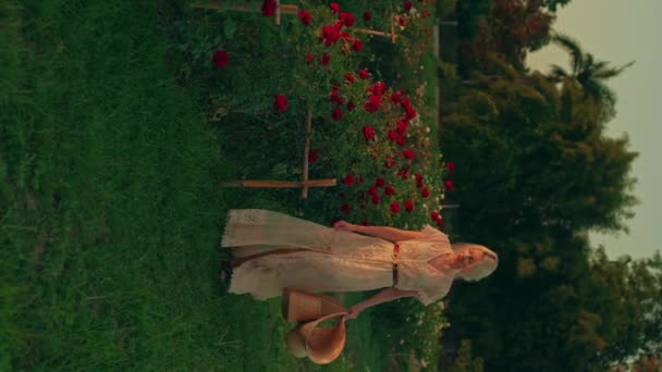 Młoda Blondynka Białej Koronkowej Sukience Słomkowym Kapeluszu Spaceruje Pięknym Ogrodzie — Wideo stockowe