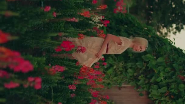 빨간색과 분홍색 꽃으로 화려한 필드에서 레이스 드레스에 시골의 초상화 비디오 — 비디오