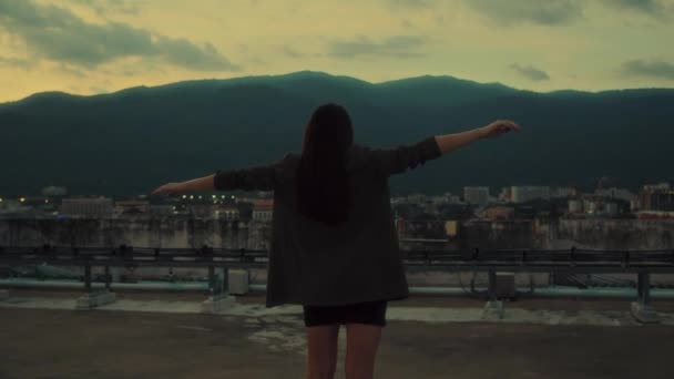 若いブルネットの少女の手は 日没に山の景色を望む屋上で踊るスーツのドレスで広く開いています 若者のコンセプト4K映像 高品質の4K映像 — ストック動画