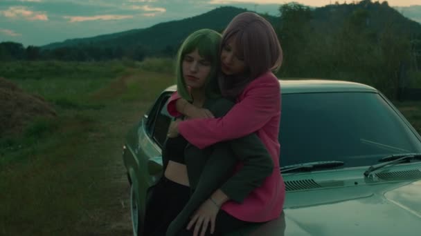 Κορίτσι Ζευγάρι Χρωματιστά Μαλλιά Bob Αγκαλιάζει Κοντά Στο Ρετρό Αυτοκίνητο — Αρχείο Βίντεο