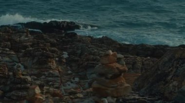 4K 'lık bir kaygan kayalık sahil ve deniz dalgalarının kayalara çarpma videosu. Yüksek kalite 4k görüntü