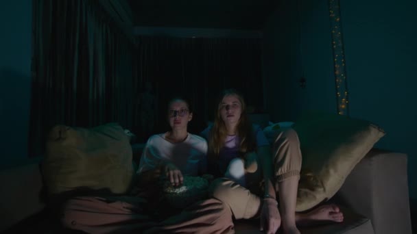 Duas Jovens Mulheres Sentadas Comendo Pipocas Pijama Sofá Acolhedor Casa — Vídeo de Stock