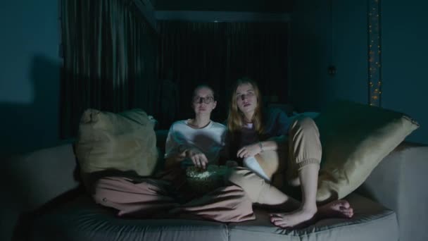 Duas Jovens Mulheres Sentadas Comendo Pipocas Pijama Sofá Aconchegante Casa — Vídeo de Stock