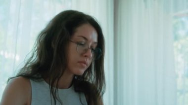 Gözlüklü bir iş kadını akıllı telefon ve laptop kullanıyor, internette sörf iletişimi kuruyor. Telefonu elinde tutan güzel bir kız öğrenci. Kapatın. Yüksek kalite 4k görüntü