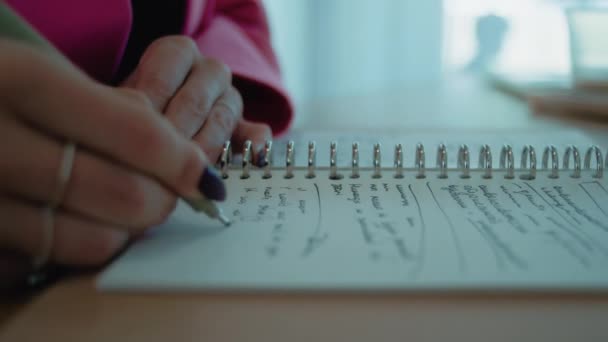 ノートにペンでメモを作るクローズアップ女性 コワーキングスペースのテーブル 高品質の4K映像 — ストック動画