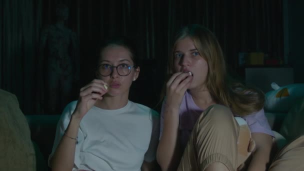 Zoom Portrait Two Young Women Sitting Eating Popcorn Pajamas Cozy — Stock Video