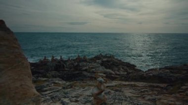 Manzaralı, alışılmadık volkanik kaya oluşumlarının ve bir uçurumun kenarından görülen deniz kıyısının 4K sürgülü görüntüsü. Yüksek kalite 4K görüntü. Uzaklaştır