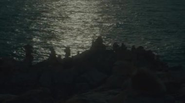 Bir 4K kaydırak görüntüsü, alışılmadık volkanik kaya oluşumları ve günbatımı dalgaları bir uçurumun kenarından görülüyor. Yüksek kalite 4k görüntü