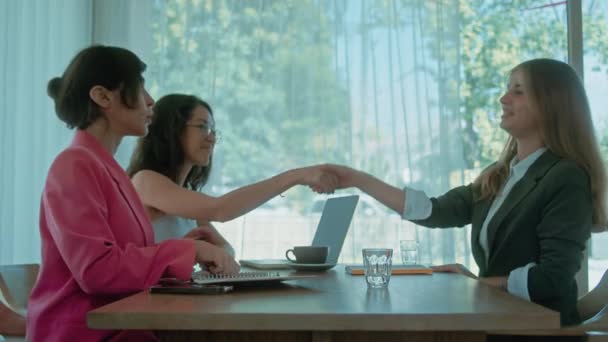 女性はビジネスミーティングを終え 握手をする 3人の女性がコーヒーとコワーキングスペースで合意し 握手をした 同僚に別れを告げ 去っていく 高品質の4K映像 — ストック動画