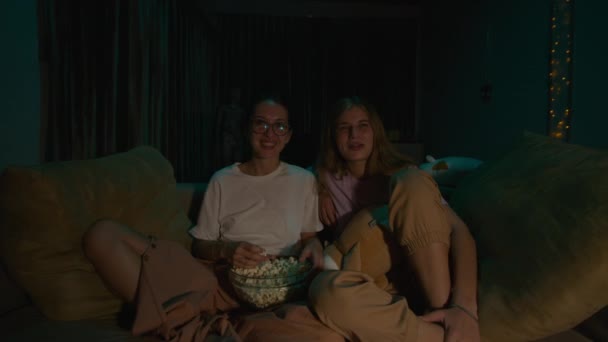 Zoom Duas Jovens Mulheres Sentadas Comendo Pipocas Pijama Sofá Aconchegante — Vídeo de Stock