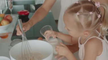 Mutfakta kaynaşan bir anne ve kızın doğal malzemelerle çırpıcıyı karıştırıp birlikte yemek hazırladığı yürek ısıtan bir video.