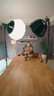 Çevrimiçi izleyiciler için içerik yaratmak için modern bir ortamda profesyonel ışıklandırma ve ekipman kullanan bir vlogger