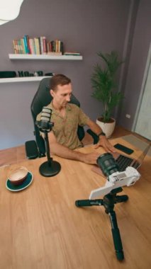 Bir podcaster, yüksek kaliteli kayıtlar için mikrofonları, ışıkları ve dizüstü bilgisayarı olan bir stüdyodan çalışır.
