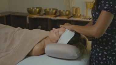 Bir insan, profesyonel güzellik ve cilt terapisinden yararlanarak spa 'da yatıştırıcı bir yüz tedavisi görüyor.