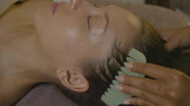 Bir kadın spa 'da rahatlatıcı bir yüz masajından hoşlanır, cilt rutinlerine ve genel olarak iyi olmaya odaklanır.