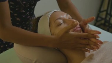 Bir insan, profesyonel güzellik ve cilt terapisinden yararlanarak spa 'da yatıştırıcı bir yüz tedavisi görüyor.