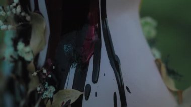 Alacakaranlıkta bir tarlada duran bir mankenden aşağı kırmızı ve siyah sıvı damlıyor. Vücuda yapışan kuru yaprakların üzerinden boya akıyor.