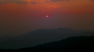 Güzel kırmızı renklerin zamanlaması. Gün batımı gökyüzü dağların üzerinde. Doğa geçmişi, karanlık, zaman atlaması. Hava değişikliği. Güneş şekil değiştiriyor. Yüksek kalite 4k görüntü