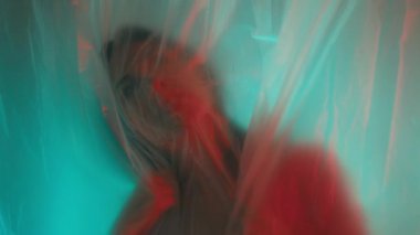 Plastik örtü ve canlı ışıklandırma efektleri içeren gerçeküstü bir portre duygu ve yaratıcılığı çağrıştırıyor..